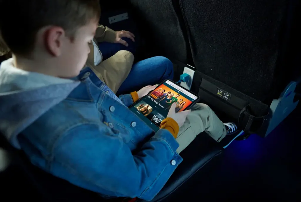 A boy using the onboard entertainment in Greyhound coach